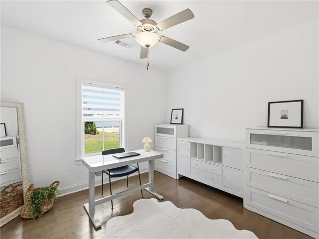 A well-lit study with polished hardwood flooring offers a productive and tranquil workspace.