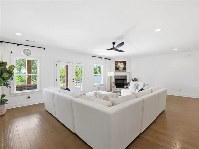 Natural light pours into this living space with a fireplace and beautiful hardwood flooring.