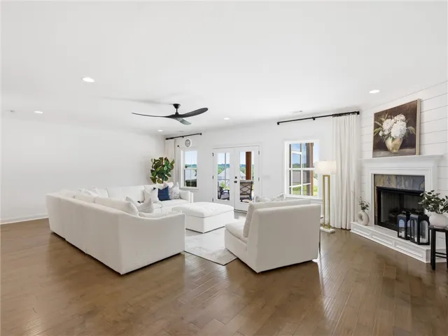 Warm hardwood floors and a cozy fireplace create a welcoming ambiance in this generous living area.