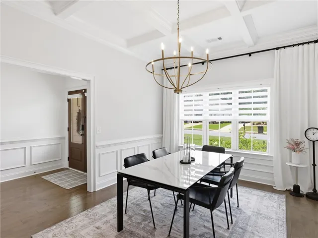 Hardwood floors and a coffered ceiling elevate this inviting dining space, ready for memorable meals.