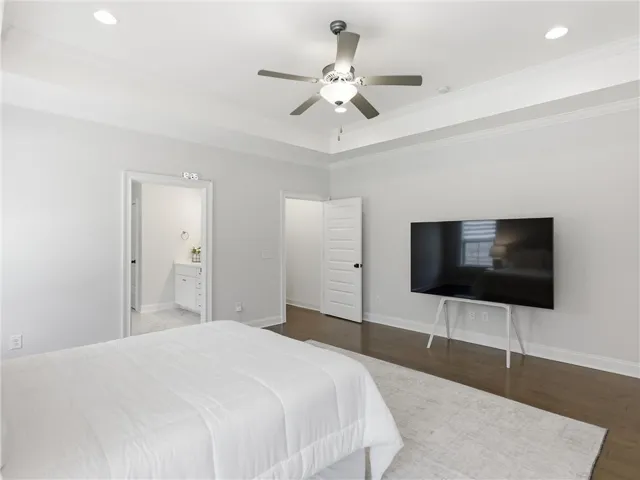 Recessed lighting and a stylish ceiling fan complement the polished hardwood flooring in this spacious bedroom.