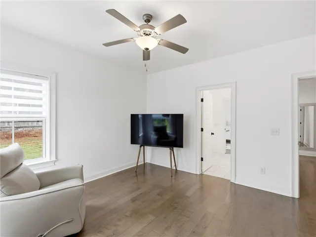A quiet living area provides a peaceful retreat with rich hardwood flooring and a bright window.