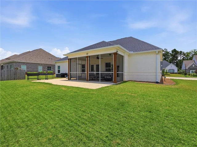 A spacious lawn unfolds from a private screened patio, perfect for enjoying outdoor moments.