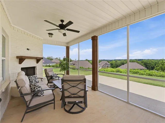 An inviting screened porch provides a peaceful outdoor sanctuary with a view of the surrounding landscape.