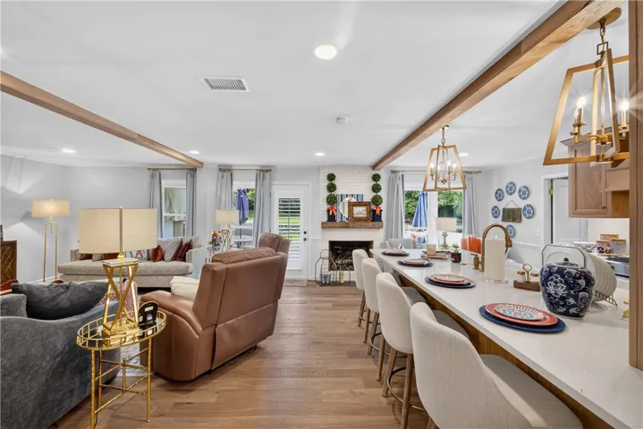 Exposed wood beams add a touch of rustic charm to this bright, open-concept living and kitchen area.