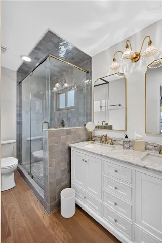 A refined bathroom featuring a spacious glass-enclosed shower and dual vanities.