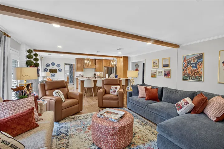 Exposed wood beams add architectural character to this open-concept living space with a connected kitchen.