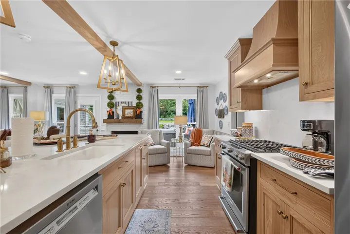 Natural wood tones and bright white countertops enhance this open-concept kitchen with seamless access to outdoor living.