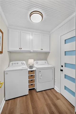 A well-appointed laundry room features a washer and dryer, complemented by overhead cabinetry.