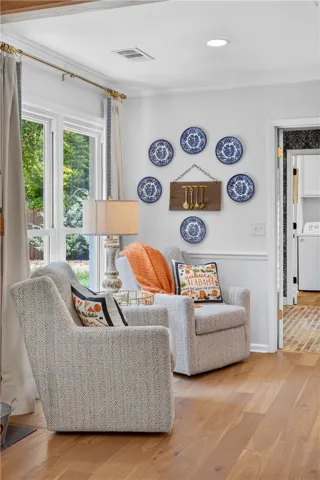 Wood floors complement this charming living area, offering a seamless flow and an abundance of natural light through generous windows.