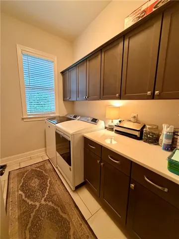 Functional laundry room featuring a convenient folding counter and ample overhead cabinetry.