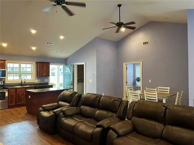 Soaring ceilings and recessed lighting define this inviting open-concept living space.