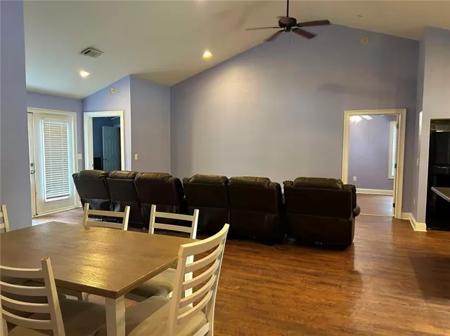 Hardwood floors flow through this welcoming living space, anchored by a vaulted ceiling.