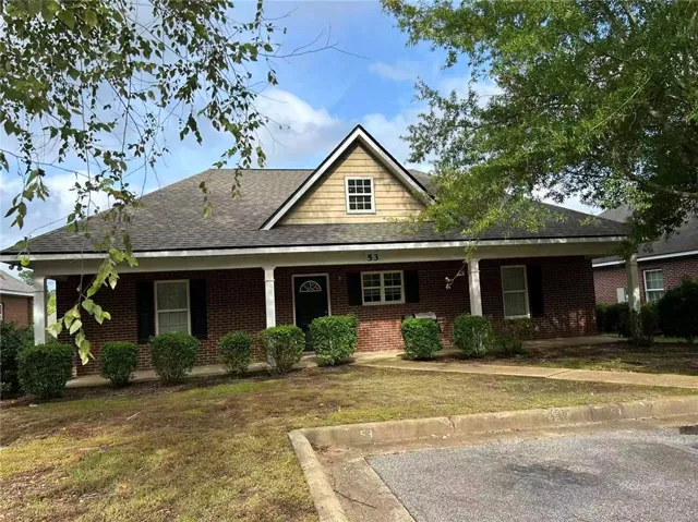 A charming brick exterior with inviting covered porch and neat landscaping awaits.