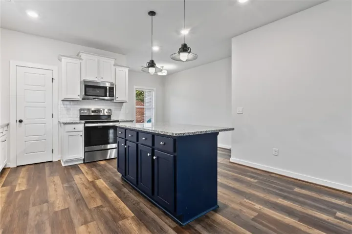 Kitchen with granite counter tops, stainless steel appliances, and a walk in pantry.