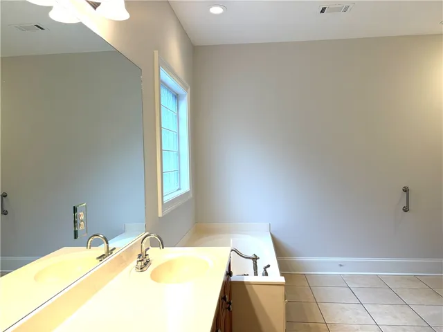 Dual vanities and a deep soaking tub create a luxurious primary bathroom retreat.