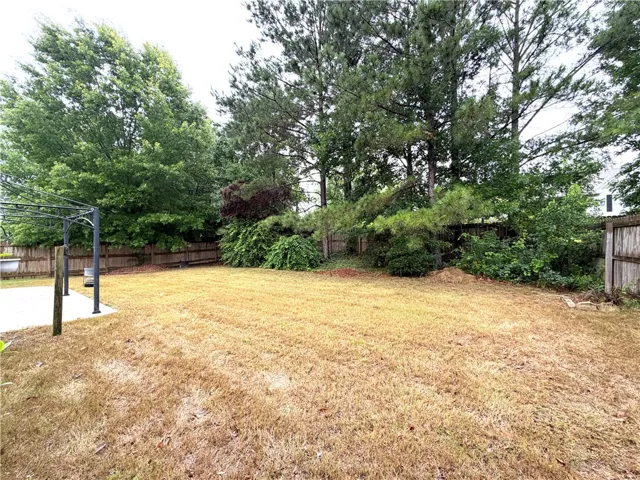 A fully fenced backyard with a large grass area offers private outdoor enjoyment.