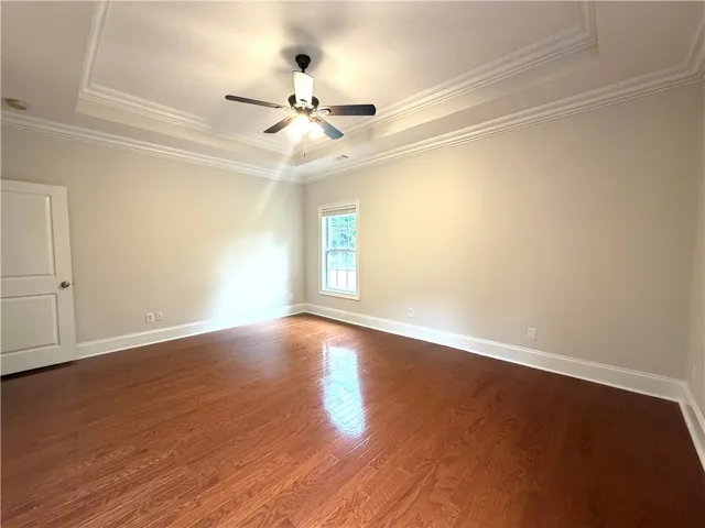 Hardwood floors and a tray ceiling define this elegant bedroom retreat.