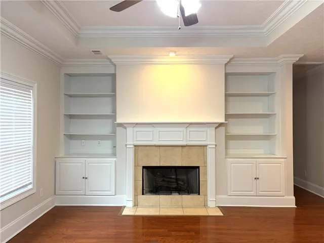 Elegant built-in shelving flanks a grand fireplace, creating a focal point in this inviting living space.