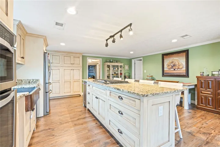 A well-appointed kitchen showcasing a spacious island with a gas cooktop, ideal for culinary creations and gatherings.
