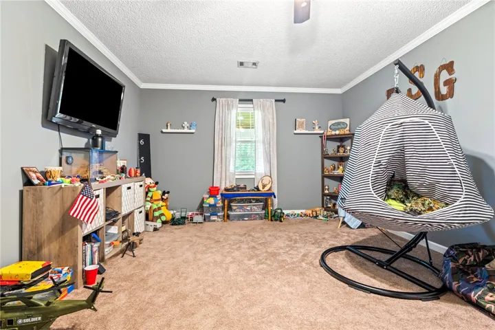 A well-lit bedroom features ample floor space, crown molding, and a single​​‌​​​​‌​​‌‌​‌‌​​​‌‌​‌​‌​‌​​​‌​​ window.
