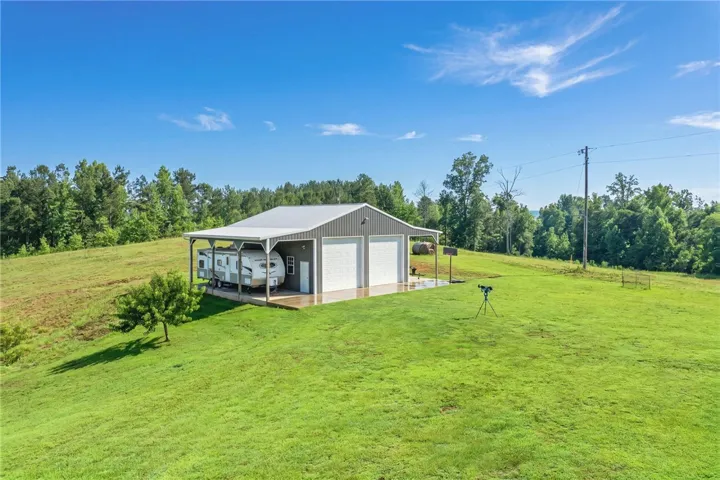 A spacious barn provides abundant storage and covered parking amidst verdant rolling hills.