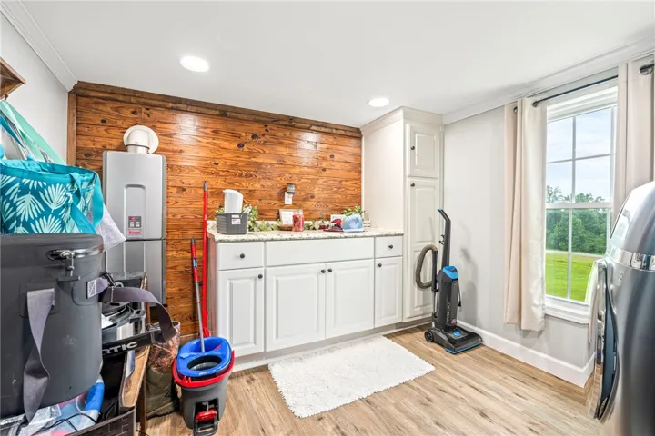 Functional utility space featuring wood-look flooring and ample cabinetry.