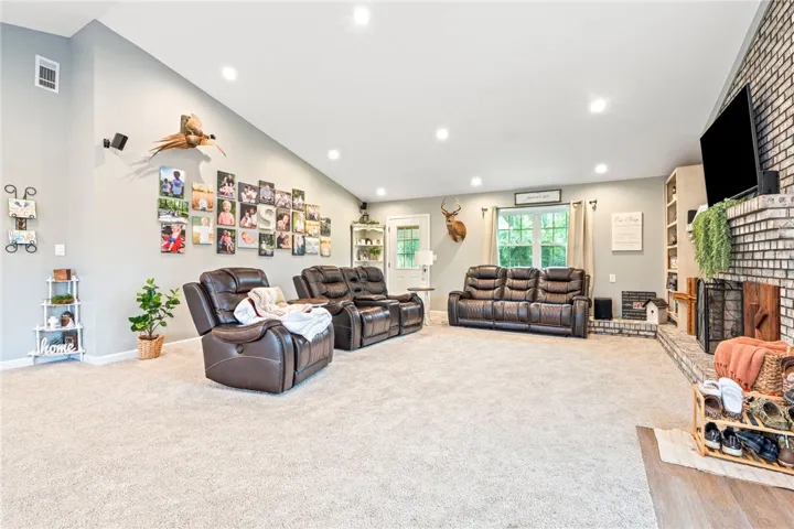 Comfortable living space with vaulted ceilings and a classic brick fireplace.