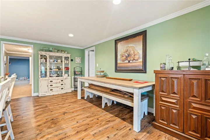 Rich hardwood-style flooring extends across this bright dining area, offering a warm and inviting space for meals.