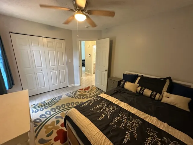 A well-appointed sleeping sanctuary featuring an integrated closet and a modern ceiling fan for comfort.