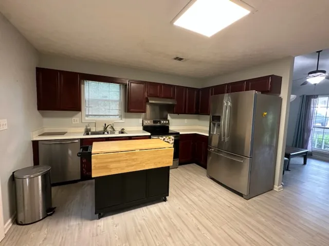 A well-appointed kitchen features ample cabinetry, a full suite of appliances, and a mobile island for flexible meal prep.
