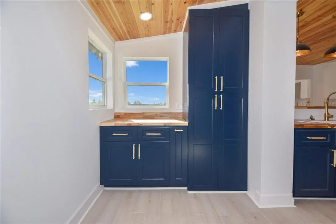 Bold navy cabinetry and warm wood accents define this well-lit kitchen space.