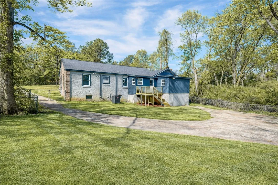 A quiet retreat with a spacious yard and private driveway, surrounded by mature trees.