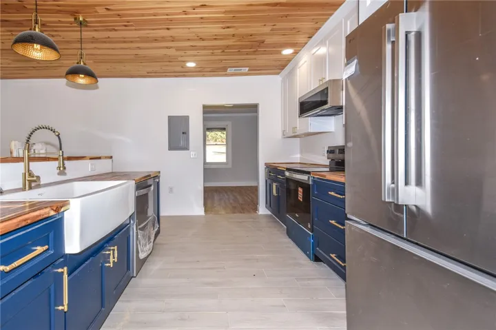 Culinary aspirations find their home in this freshly appointed kitchen with a striking wood-planked ceiling.