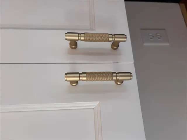These white cabinet doors are accented with chic, textured brass handles.