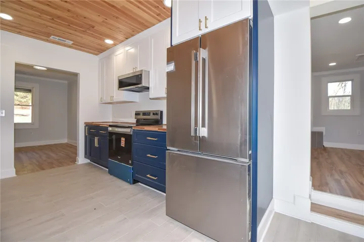 Culinary aspirations come alive in this meticulously appointed kitchen, featuring elegant wood ceilings and modern appliances.