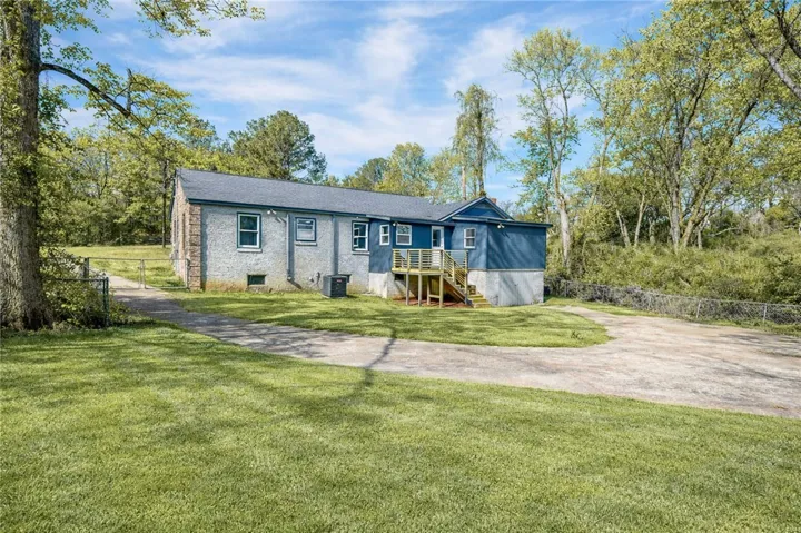 A quiet retreat with a spacious yard and private driveway, surrounded by mature trees.
