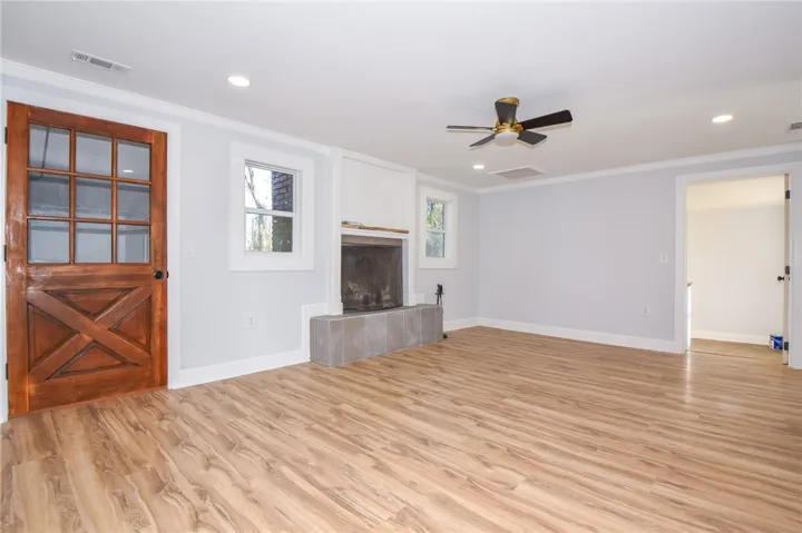 A welcoming living area boasts durable hardwood flooring and a cozy fireplace with a tiled hearth.