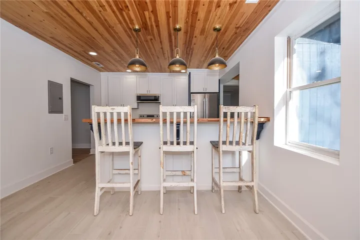 A striking wood-paneled ceiling highlights this kitchen's well-appointed breakfast bar.