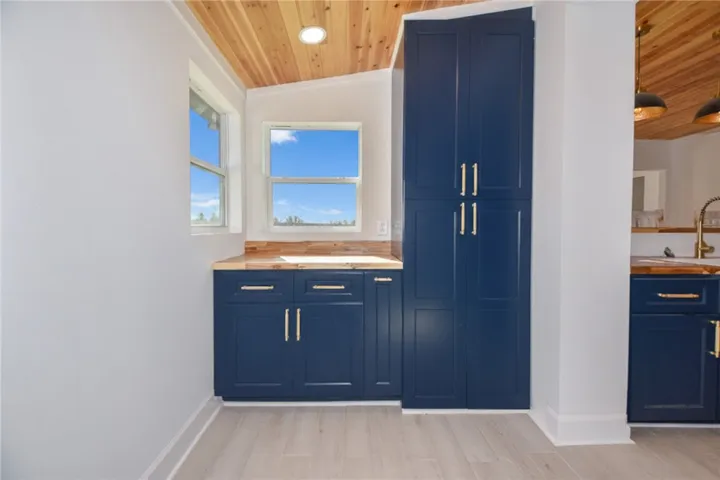 Bold navy cabinetry and warm wood accents define this well-lit kitchen space.