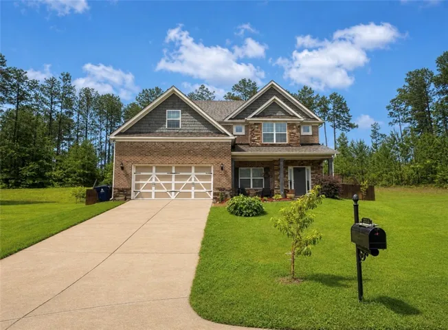 A classic brick and siding residence with an inviting front porch and mature landscaping.