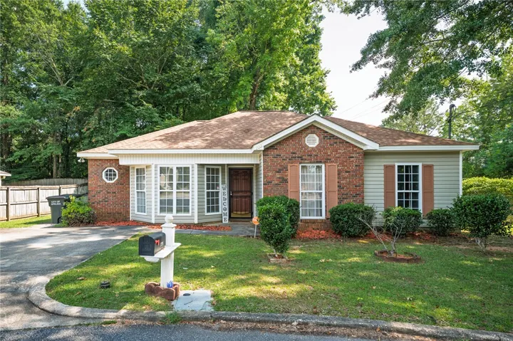 A classic brick and siding residence with mature landscaping and welcoming curb appeal.