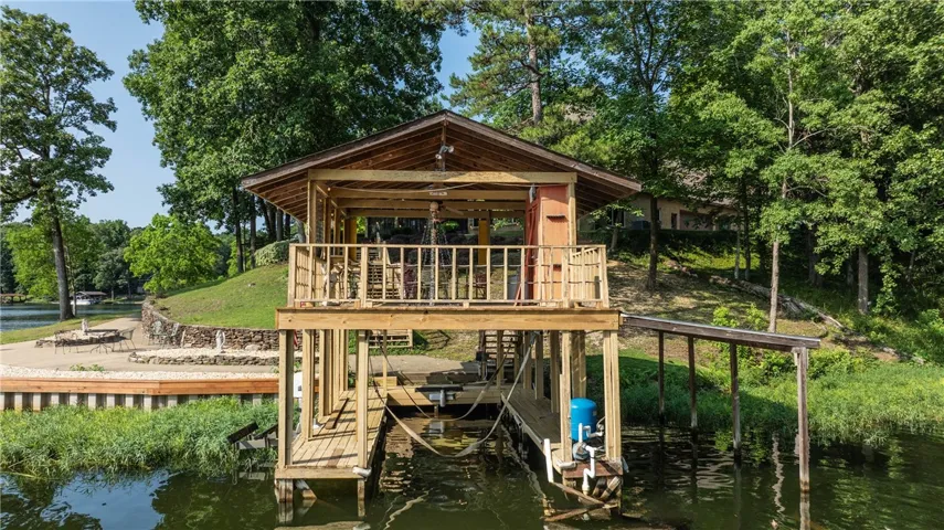 Boathouse with a second-story deck overlooking a serene waterfront.