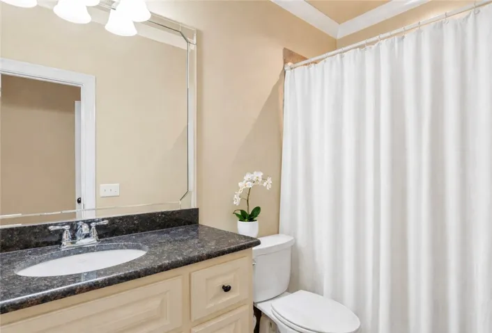 Granite counters and elegant cabinetry complete this well-appointed bathroom.