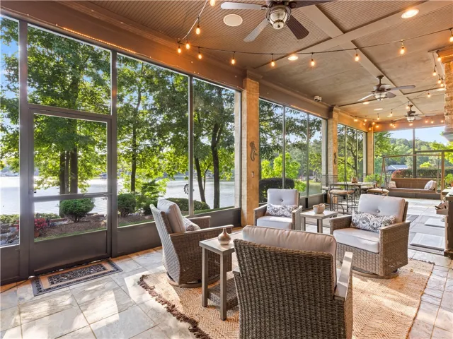A spacious sunroom with tile flooring and ceiling fans, perfect for enjoying waterfront views.