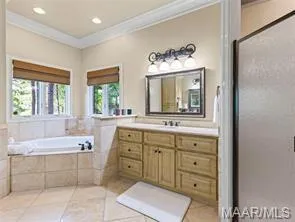 A well-lit primary bathroom features a generous soaking tub and a spacious vanity with ample storage.