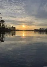 Golden hour glow over tranquil waters, reflecting nature's beauty.