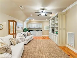Custom built-in cabinetry and shelving provide ample storage in this well-appointed living space.