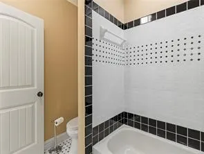 Black and white mosaic tiling frames this practical bathroom space.