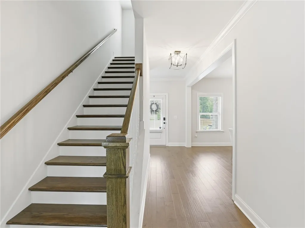 Grand entryway with rich hardwood floors and a striking staircase welcomes you home.